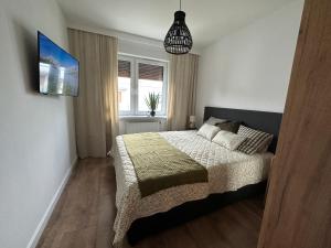 1 dormitorio con 1 cama y luz colgante en Apartament 28 w Dolinie Baryczy - 5D Apartamenty, en Milicz