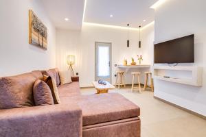 a living room with a couch and a tv at Tiara Suites Santorini in Fira