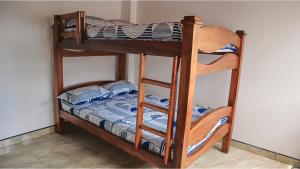 um beliche com uma escada e um beliche com uma cama de beliche. em Hostal Casa Amatista em Pereira