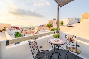 a balcony with a table and chairs and a view at Tiara Suites Santorini in Fira