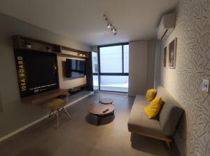 a living room with a couch and a flat screen tv at Departamento en condominio de Equipetrol in Santa Cruz de la Sierra