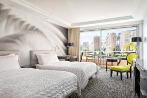 a hotel room with two beds and a window at Le Méridien Beach Plaza in Monte Carlo