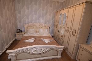 1 dormitorio con 1 cama grande y armario de madera en Guest House en Gyumri