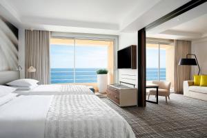 a hotel room with a large bed and a large window at Le Méridien Beach Plaza in Monte Carlo