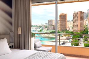 a hotel room with a bed and a large window at Le Méridien Beach Plaza in Monte Carlo