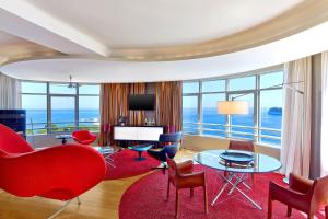 a living room with a red couch and chairs at Le Méridien Beach Plaza in Monte Carlo