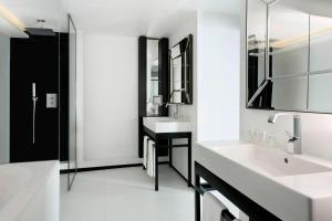 a white bathroom with two sinks and a mirror at Le Méridien Beach Plaza in Monte Carlo