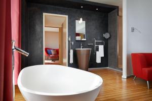 a bathroom with a white tub and a sink at Le Méridien Beach Plaza in Monte Carlo