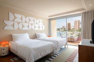 a hotel room with two beds and a balcony at Le Méridien Beach Plaza in Monte Carlo
