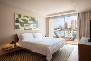 a hotel room with a bed and a large window at Le Méridien Beach Plaza in Monte Carlo
