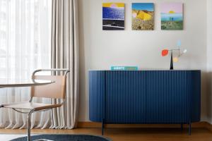 a blue cabinet in a living room with a chair at Le Méridien Beach Plaza in Monte Carlo