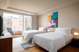 a hotel room with two beds and a balcony at Le Méridien Beach Plaza in Monte Carlo