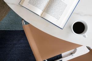 a table with an open book and a cup of coffee at Le Méridien Beach Plaza in Monte Carlo