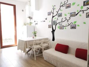 une salle à manger avec une table et un arbre sur le mur dans l'établissement Casa di Serena, à Mestre