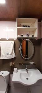 a bathroom with a sink and a toilet and a mirror at Damech Apparts in Yaoundé