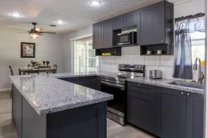 a kitchen with black cabinets and a granite counter top at Clark House Perfect for Workers! in Orange