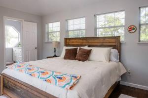 a bedroom with a large white bed with windows at Clark House Perfect for Workers! in Orange