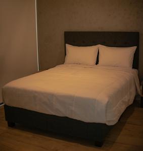 a large bed with white sheets and pillows at Awqa Loft & Camp in Trujillo