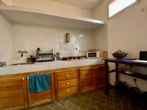 eine Küche mit einer Spüle und einer Mikrowelle in der Unterkunft Les chandelles in Tinghir