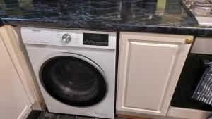 uma máquina de lavar roupa numa cozinha com bancada em HILLTOP PLACE SUITES near MEADOWHALL em Sheffield