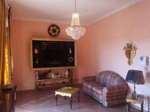 ein Wohnzimmer mit einem Sofa und einem TV in der Unterkunft La dimora di Massimo in Ponte Lucano