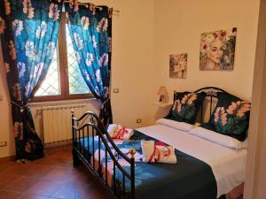 Schlafzimmer mit einem Bett und einem Fenster mit Vorhängen in der Unterkunft La dimora di Massimo in Ponte Lucano