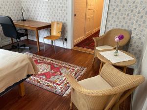 a bedroom with a bed and a table and chairs at Rum på Gårdstånga Prästgård in Flyinge