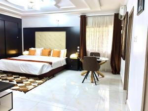 una camera da letto con un letto, una scrivania e una sedia di UrbaN RootZ ad Abuja
