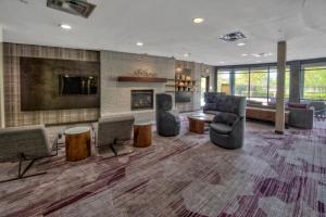 eine Lobby mit Sofas und Stühlen sowie einem Kamin in der Unterkunft Courtyard by Marriott Memphis Southaven in Southaven