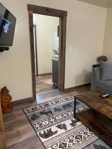 sala de estar con sofá, TV y espejo en ParkWay Yellowstone Guest House Apartment #3 en Gardiner