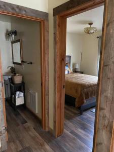 1 dormitorio con 1 cama y una puerta que conduce a una habitación en ParkWay Yellowstone Guest House Apartment #3 en Gardiner