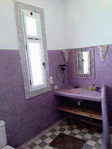 Baño púrpura con lavabo y espejo en Dar De La Milonga, en Essaouira