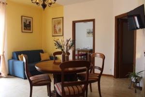 uma sala de estar com uma mesa e cadeiras e um sofá em Casa Luisa em Pitigliano