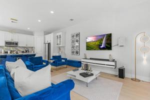 a living room with blue furniture and a kitchen at Villa De Briley in Houston