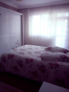 a bedroom with a bed and a window with a flowery blanket at Ultra lüks eşyalı kiralık daire in Of