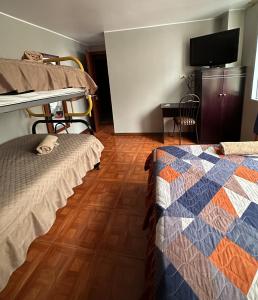 Hotel Villamar في كيتو: غرفة نوم بسريرين بطابقين وتلفزيون