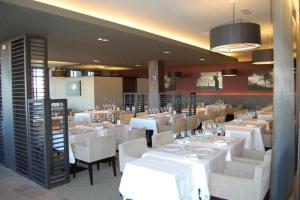 una sala da pranzo con tavoli bianchi e sedie bianche di Tu casa y lugar especial para vacaciones y momentos a Murcia