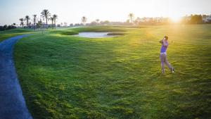 Un uomo sta in piedi su un campo da golf di Tu casa y lugar especial para vacaciones y momentos a Murcia