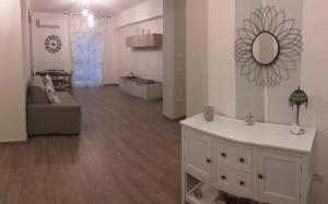 ein weißes Wohnzimmer mit einem Wandspiegel in der Unterkunft Armonia family B&b in Crotone