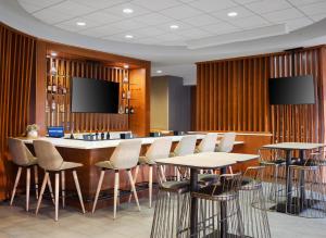 um bar com cadeiras e mesas e uma televisão de ecrã plano em SpringHill Suites by Marriott Pittsburgh Mt. Lebanon em Mount Lebanon