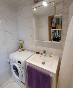 a bathroom with a sink and a washing machine at Bright 3-room apartment in Mustamäe in Tallinn