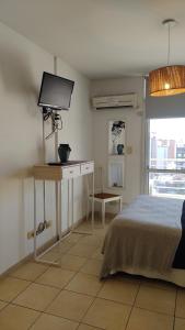 1 dormitorio con 1 cama y escritorio con TV en Moreno1300/9 en Rosario