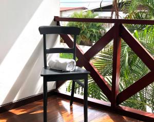 a black chair with a white pillow on a balcony at Villa Famiri Boutique hotel in Paramaribo