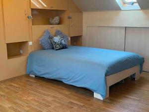 1 dormitorio con 1 cama grande con sábanas azules en Ruim duplexappartement Oostende met groot terras, en Ostende