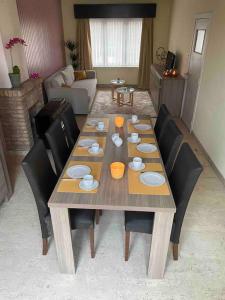 una mesa de madera en una sala de estar con sillas en Ruim duplexappartement Oostende met groot terras, en Ostende
