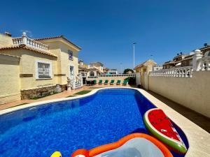 ein Pool mit einem Spielzeugboot neben einem Haus in der Unterkunft Villas Yanina Luxe Gran Alacant in Puerto Marino