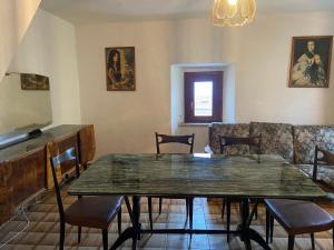 a dining room with a table and a couch at La Casa nell’Antico Borgo in Alvito