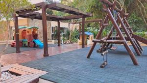 einen Spielplatz mit Rutsche und Schaukel in der Unterkunft Recanto das Tartarugas - Guarujá in Guarujá