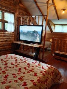 a bedroom with a bed with a flat screen tv at Cabaña en la Calera el refugio campestre in La Calera