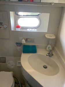 a bathroom with a sink and a window in an airplane at Beautiful Kiwi Boat in Barcelona